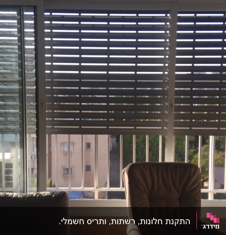 תריסי אלומיניום על חלון זכוכית בסלון